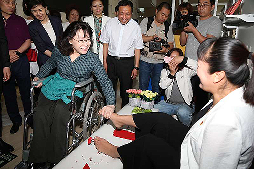 圖為張海迪與用腳剪剪紙、做絹花的殘疾人親切交談 圖為張海迪與用腳剪剪紙、做絹花的殘疾人親切交談